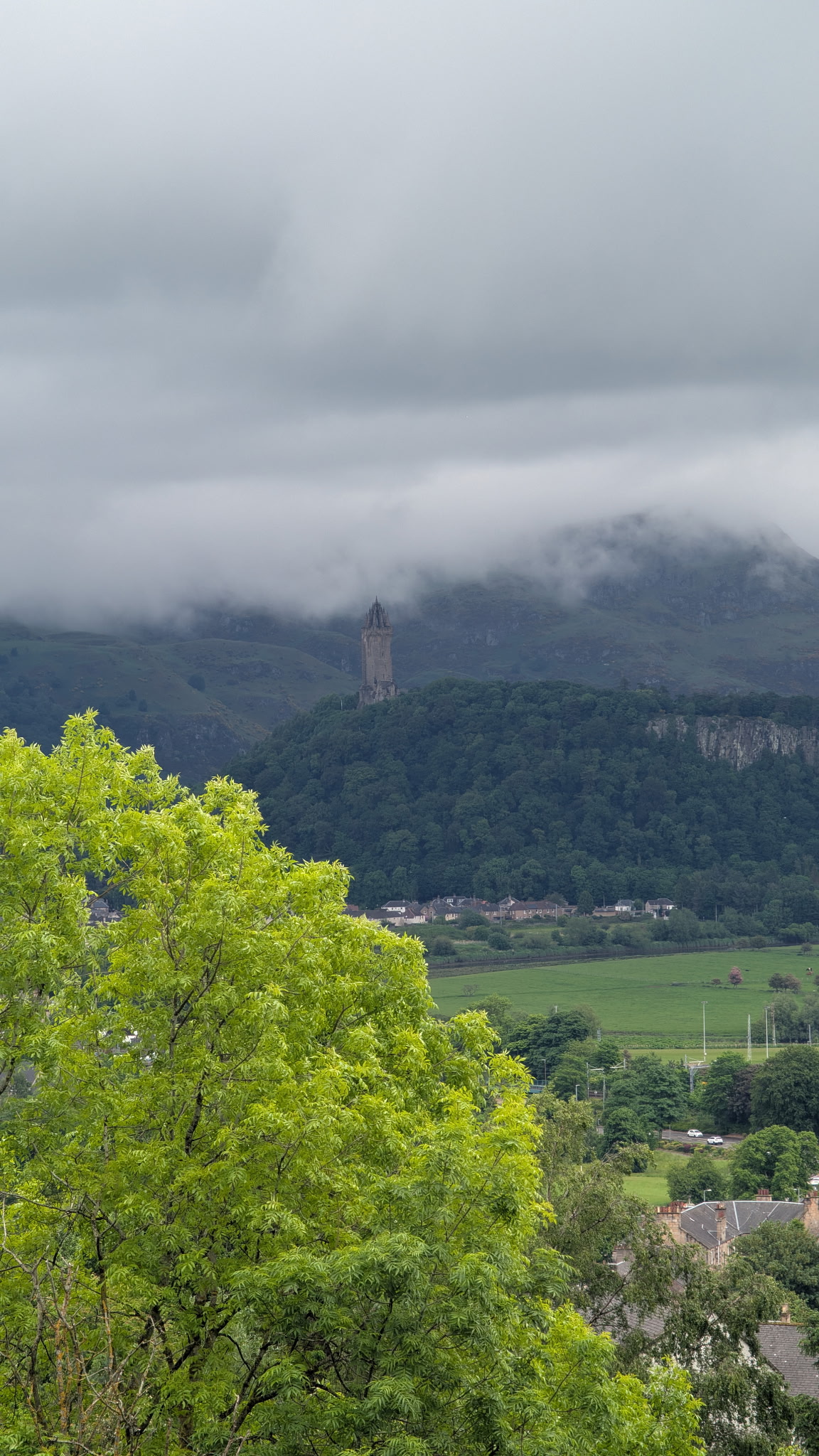 The Wallace Monument rising above misty Scottish hills